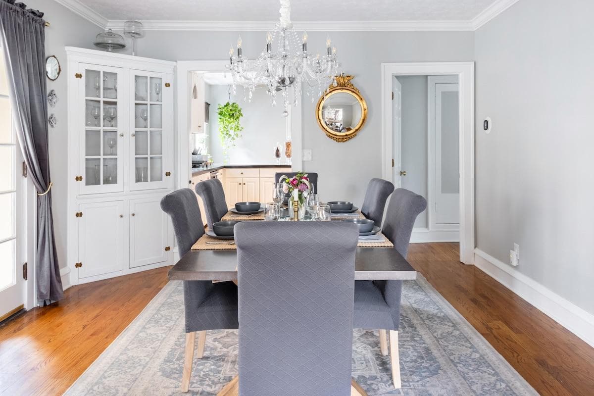 Special features of this spacious dining room include an oversize zinc-top table, crystal chandelier, vintage fish-eye mirror and century old built-ins.  